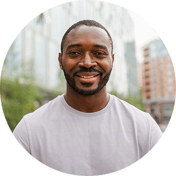 Smiling man outdoors with urban background.